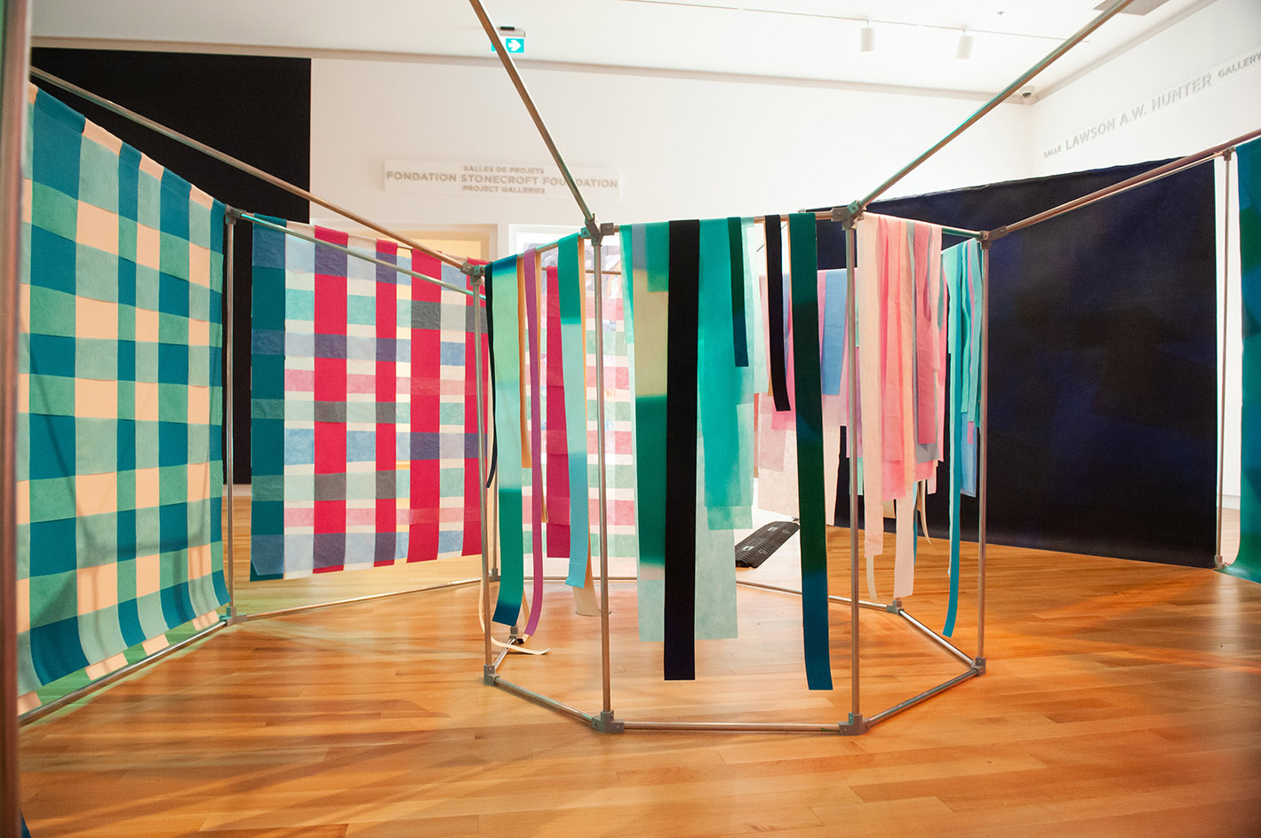 a structure featuring geometric shapes with colourful fabric hanging from the structures